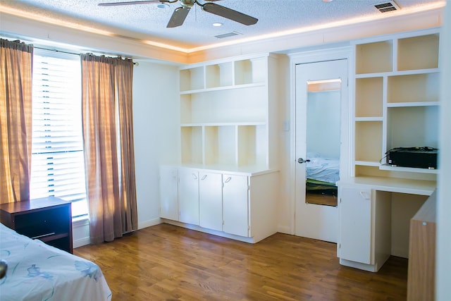 bedroom with ceiling fan, a textured ceiling, and hardwood / wood-style floors