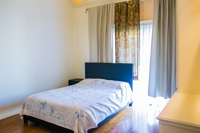 bedroom featuring wood-type flooring and crown molding