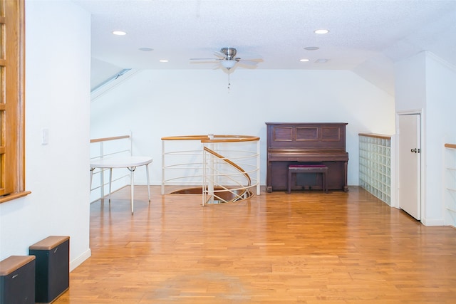 additional living space featuring ceiling fan, a textured ceiling, light wood-type flooring, and lofted ceiling