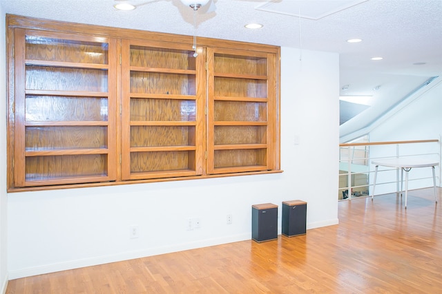 spare room featuring a textured ceiling and light hardwood / wood-style flooring