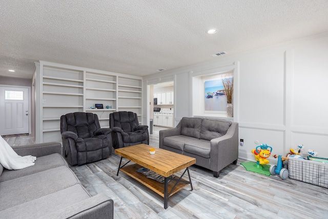 living room featuring light hardwood / wood-style floors and a textured ceiling