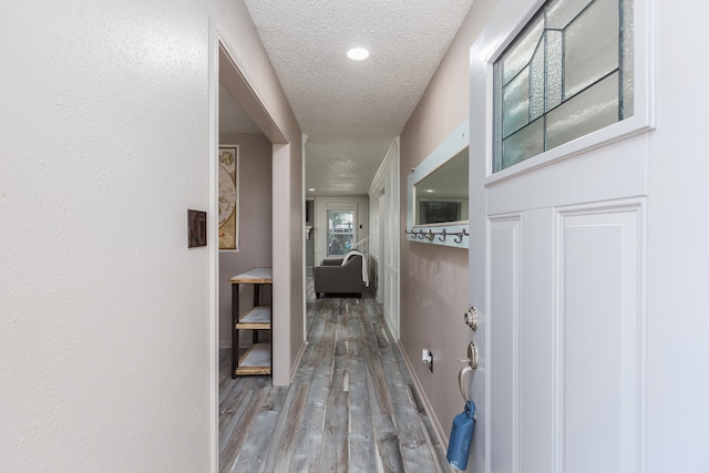 hall featuring a textured ceiling and light wood-type flooring