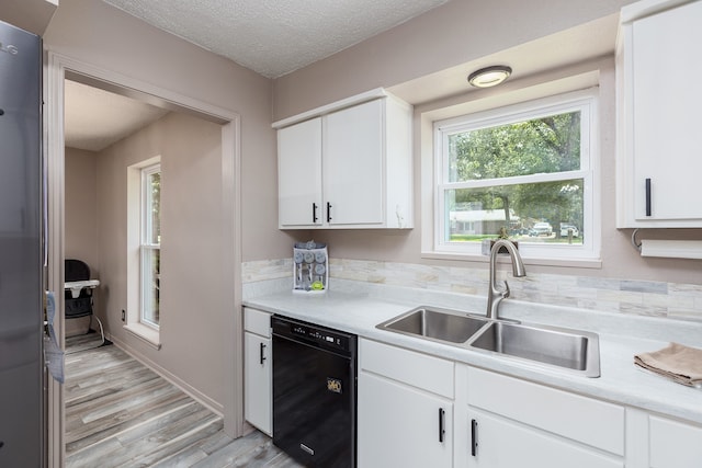 kitchen with dishwasher, white cabinets, sink, and light wood-type flooring