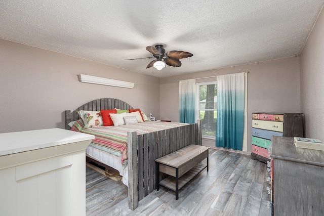 bedroom featuring hardwood / wood-style floors, a textured ceiling, and ceiling fan