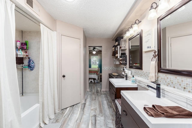 bathroom featuring vanity, a textured ceiling, wood-type flooring, and ceiling fan