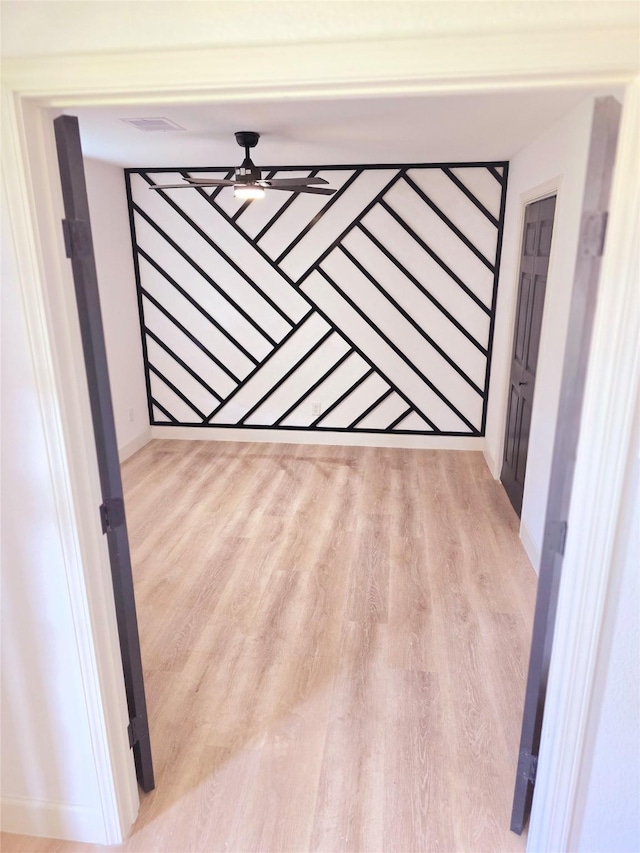 empty room featuring ceiling fan and light hardwood / wood-style flooring