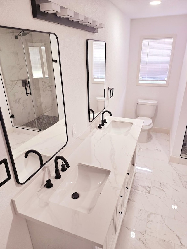 bathroom with toilet, vanity, and a shower with door