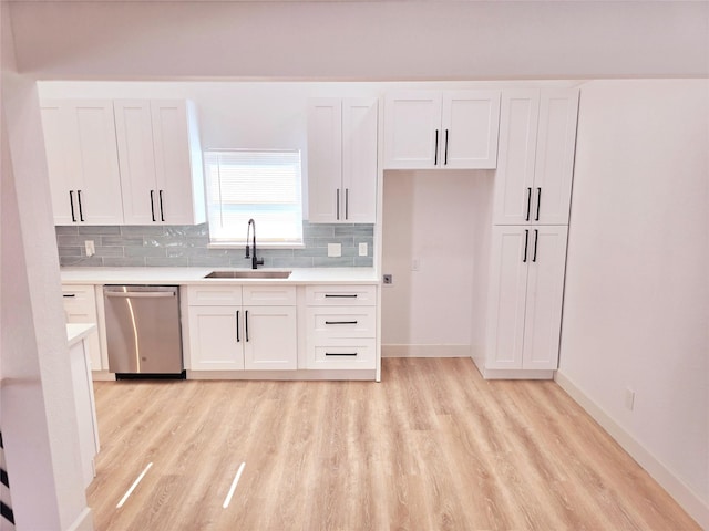 kitchen featuring stainless steel dishwasher, sink, and white cabinets