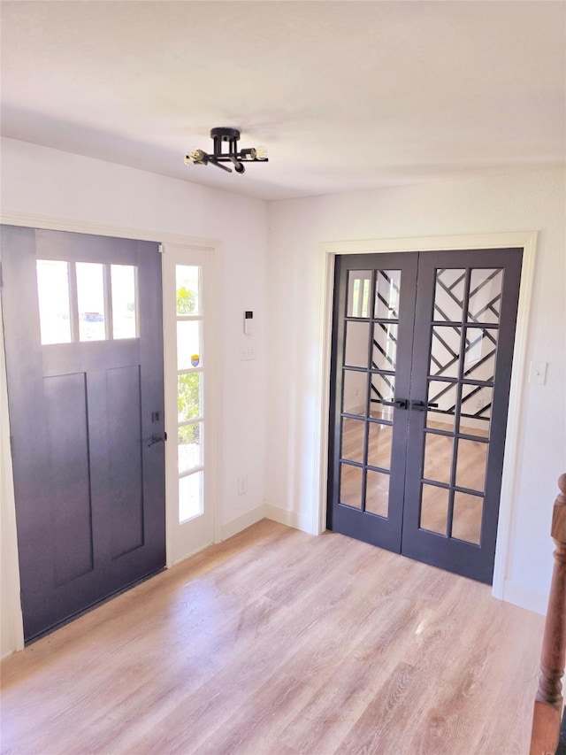 entryway with french doors and light hardwood / wood-style floors