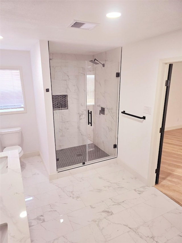 bathroom featuring an enclosed shower and toilet