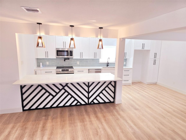 kitchen with decorative light fixtures, white cabinetry, stainless steel appliances, and decorative backsplash