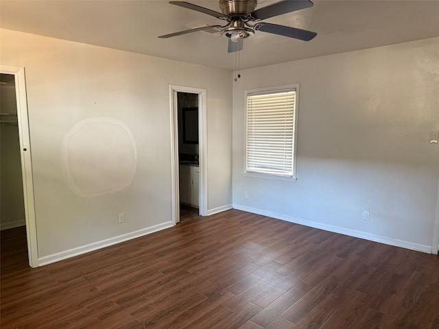 unfurnished bedroom with connected bathroom, dark hardwood / wood-style flooring, a closet, ceiling fan, and a walk in closet