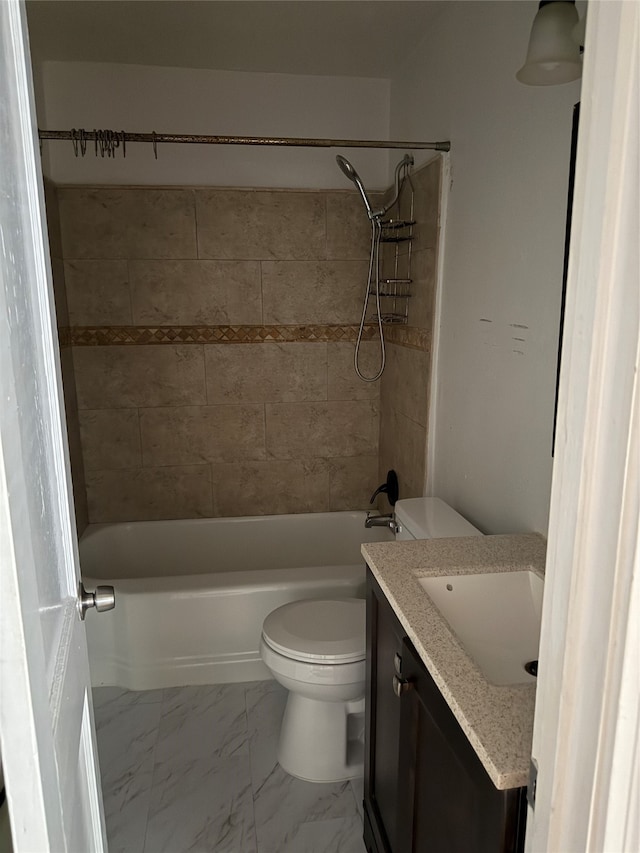 full bathroom featuring tiled shower / bath, vanity, and toilet