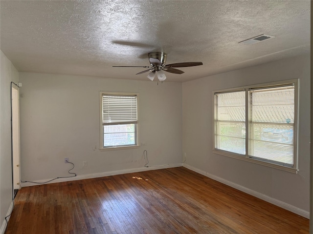 unfurnished room with wood-type flooring, ceiling fan, a textured ceiling, and visible vents