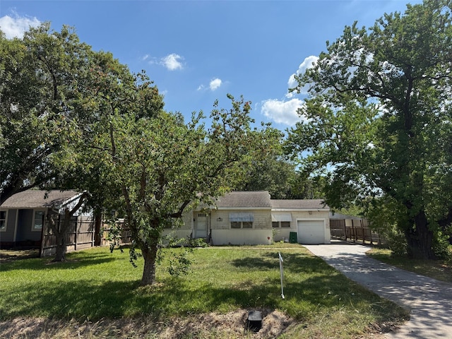 view of front of house with an attached garage, driveway, fence, and a front yard