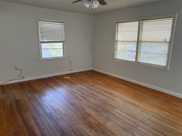 empty room with ceiling fan, baseboards, and wood finished floors