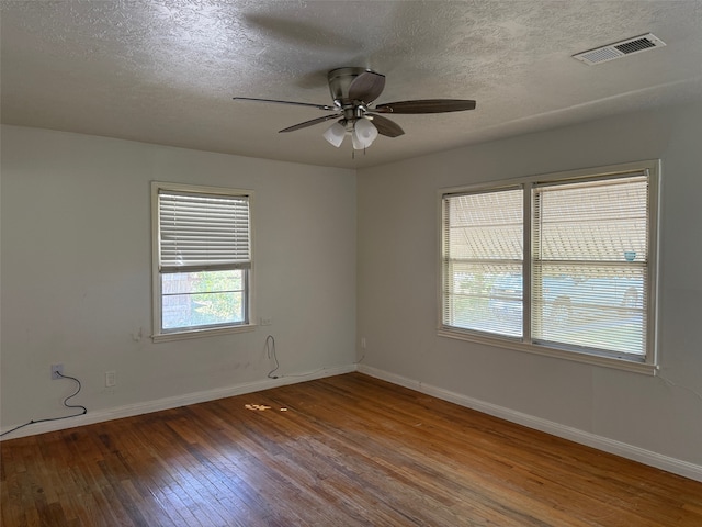 empty room with a textured ceiling, hardwood / wood-style flooring, and ceiling fan