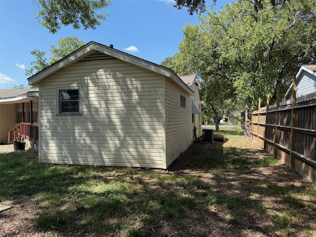 view of side of property featuring central air condition unit and fence