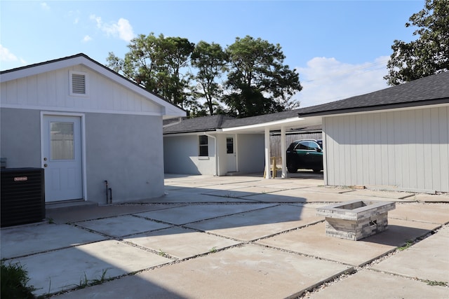 back of house with central AC, a patio, and an outdoor fire pit