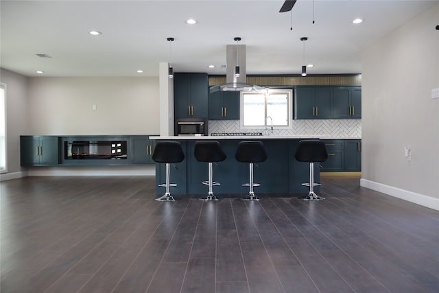 kitchen featuring pendant lighting, a center island, dark wood-type flooring, a kitchen breakfast bar, and island range hood