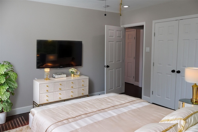 bedroom with light hardwood / wood-style floors and a closet