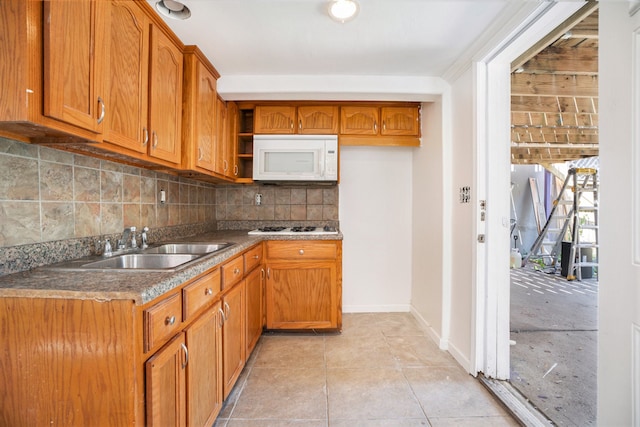 kitchen with backsplash, white appliances, light tile patterned flooring, and sink