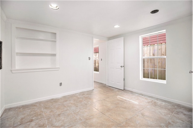 tiled empty room with ornamental molding and built in features