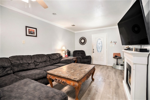 living room featuring ceiling fan, light wood-type flooring, and ornamental molding