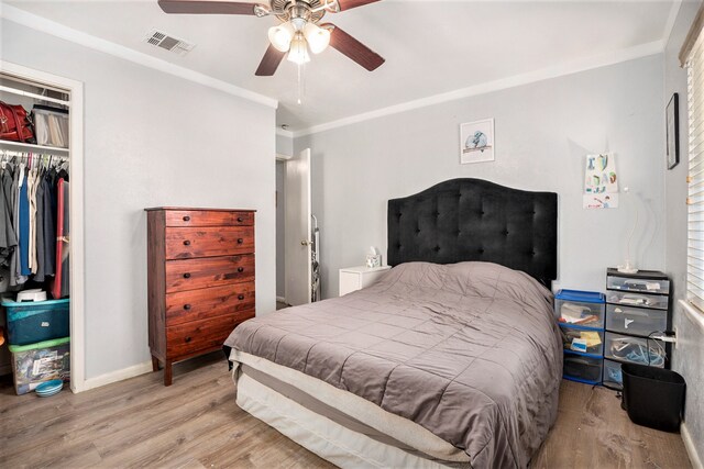 bedroom with a closet, light wood-type flooring, ceiling fan, and ornamental molding