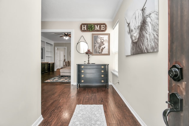 hall with built in shelves, crown molding, and dark wood-type flooring