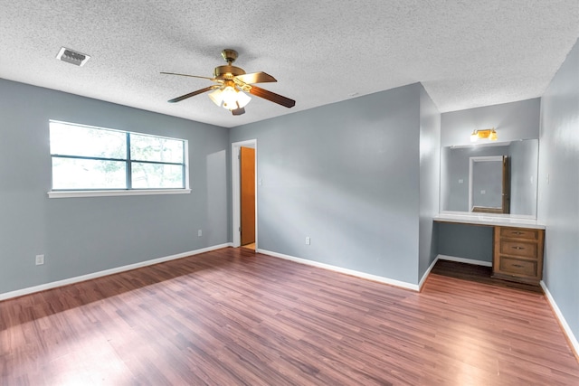 spare room with a textured ceiling, hardwood / wood-style floors, and ceiling fan