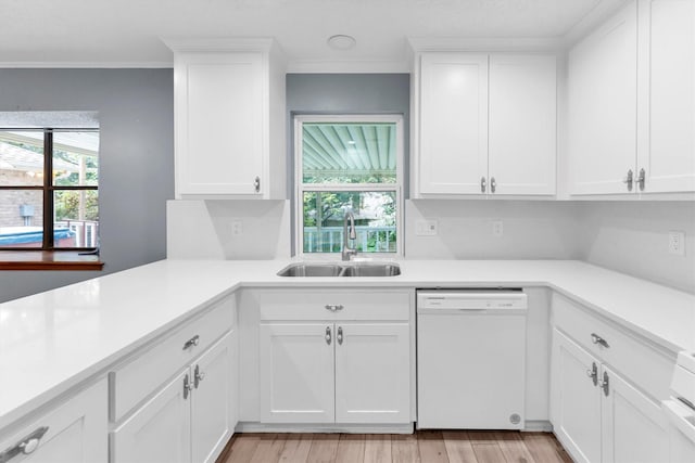 kitchen with white dishwasher, light wood-type flooring, sink, and white cabinetry