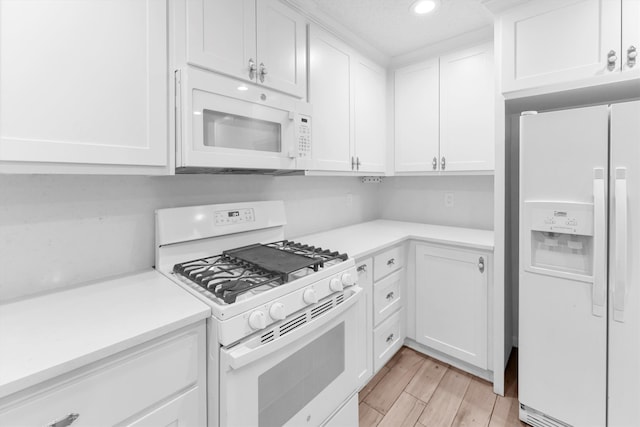 kitchen with light hardwood / wood-style flooring, white appliances, and white cabinetry