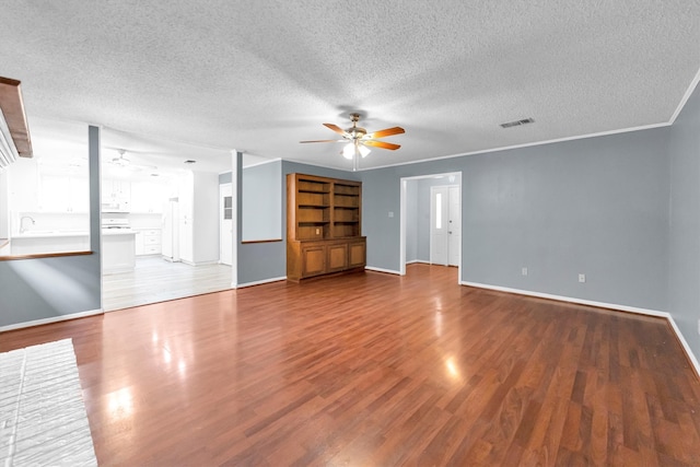 unfurnished living room featuring a textured ceiling, crown molding, hardwood / wood-style floors, and ceiling fan