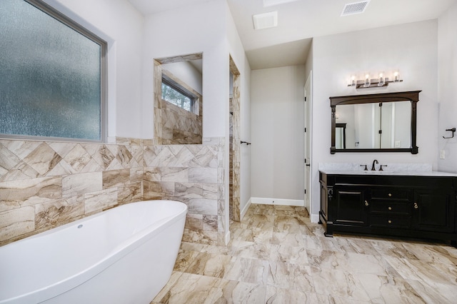 bathroom featuring vanity, a bathtub, and tile walls