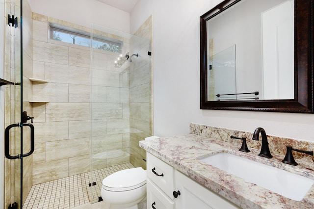 bathroom with vanity, toilet, and a shower with door