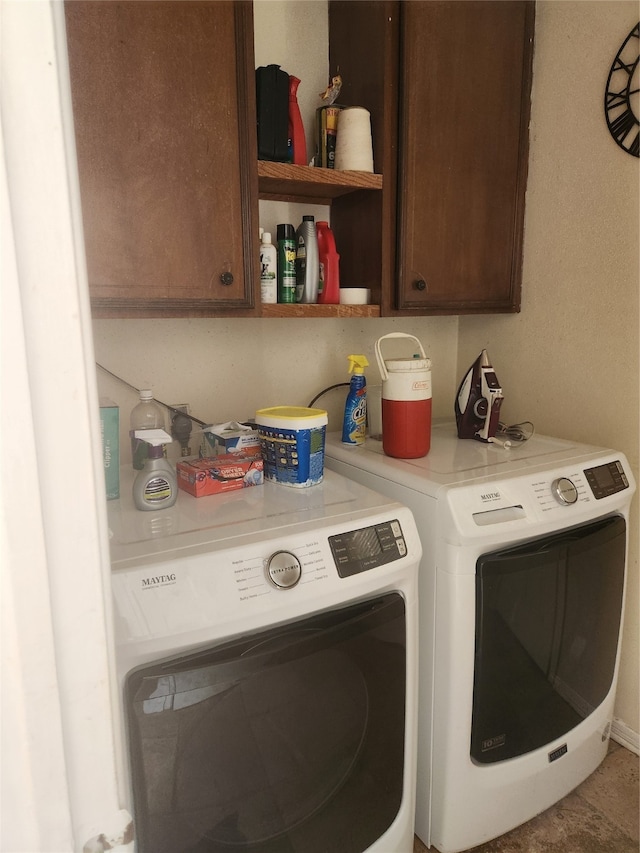 washroom with washer and dryer and cabinets