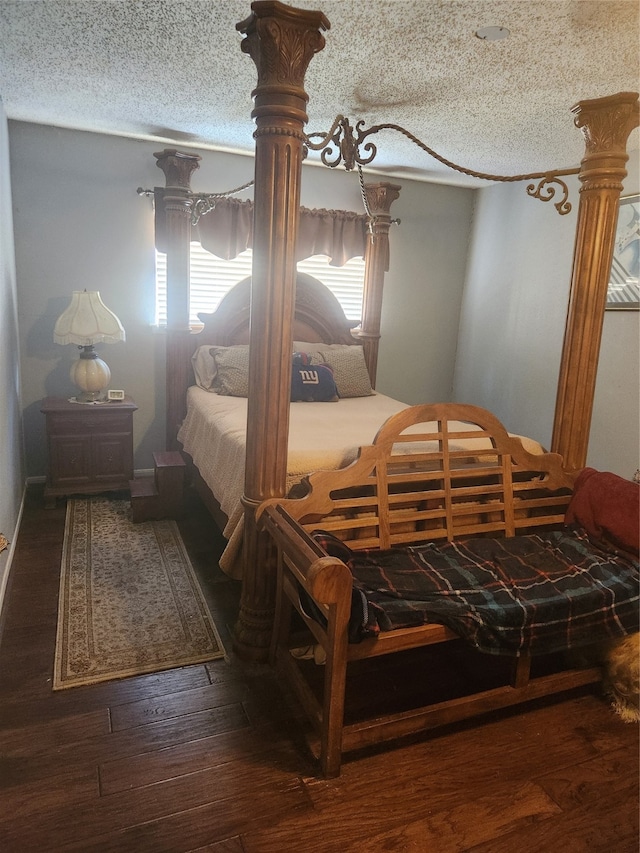 bedroom with a textured ceiling and dark wood-type flooring