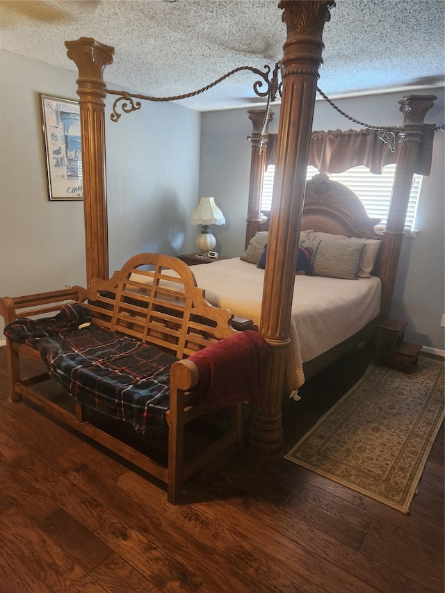 bedroom with dark hardwood / wood-style floors, a textured ceiling, and multiple windows