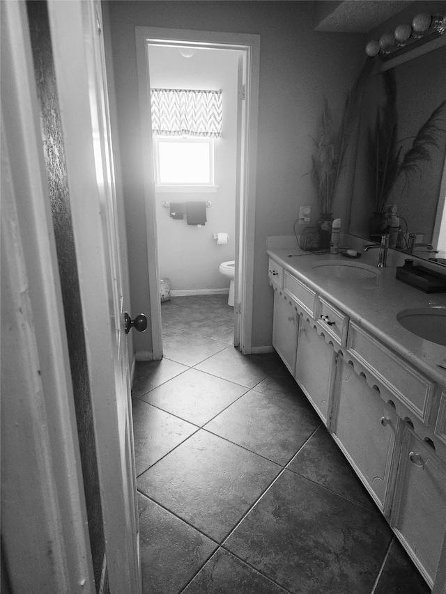 bathroom with tile patterned flooring, vanity, and toilet