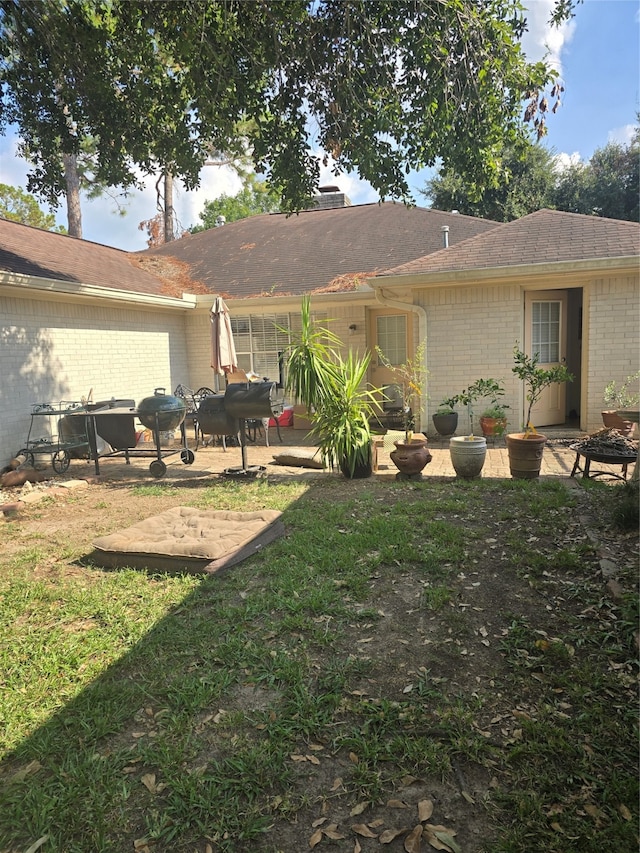 back of property with a lawn and a patio area