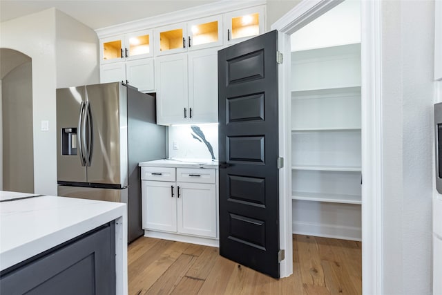 kitchen featuring white cabinets, light hardwood / wood-style floors, and stainless steel fridge with ice dispenser