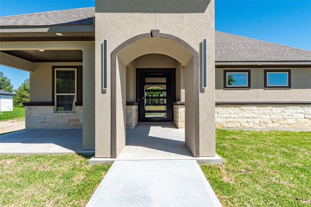 doorway to property featuring a lawn