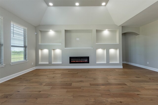 unfurnished living room with vaulted ceiling and hardwood / wood-style flooring