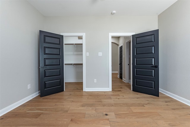 unfurnished bedroom featuring light hardwood / wood-style flooring and a closet