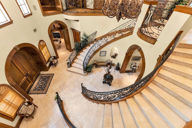 stairway featuring a notable chandelier