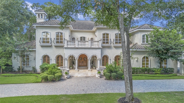 mediterranean / spanish house with a balcony and french doors