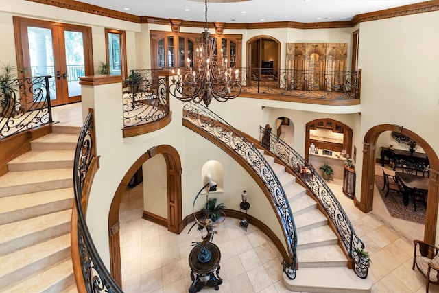 interior space featuring a notable chandelier, french doors, and crown molding