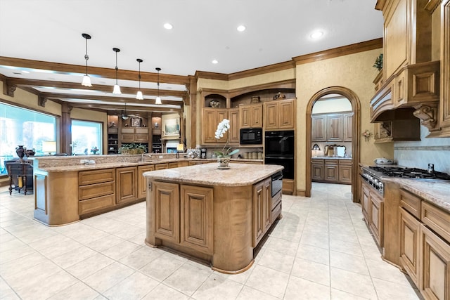 kitchen with an island with sink, hanging light fixtures, kitchen peninsula, and black appliances