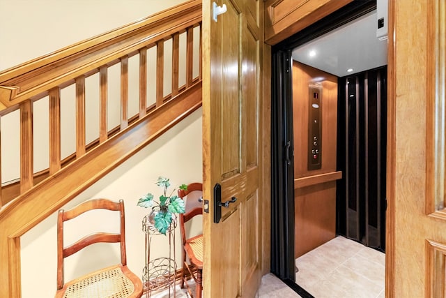 staircase with tile patterned flooring and elevator